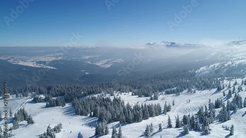 Flight over the turquoise snowy mountains illuminated by the day sun