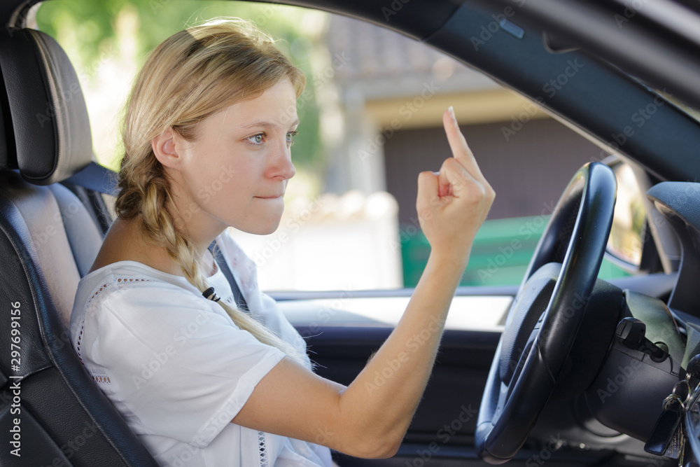 woman driving and shows middle finger out car
