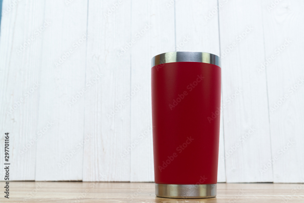 Red colour stainless steel tumbler or cold and hot storage cup on wood. Red colour stainless steel tumbler or cold and hot storage cup on wood.