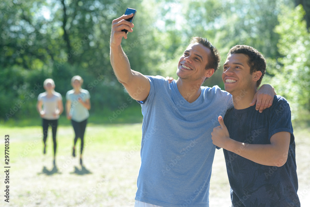 Obraz premium male runners is having break making selfie