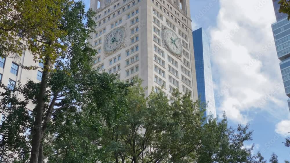 A dollying tilt up establishing shot of the tall clock tower building as seen through the trees of Madison Square Park in midtown Manhattan on an Autumn day. A dollying tilt up establishing shot of the tall clock tower building as seen through the trees of Madison Square Park in midtown Manhattan on an Autumn day.