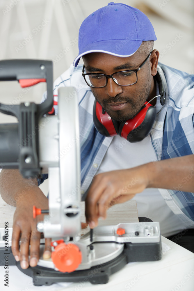 man cutting huge piece of wood by electric circular saw man cutting huge piece of wood by electric circular saw