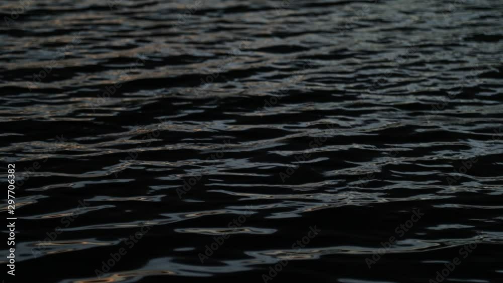 Slow motion of water ripples at sunset. Abstract scene of contrast colors movement, black blue golden and silver. Trapiche, San Luis, Argentina Slow motion of water ripples at sunset. Abstract scene of contrast colors movement, black blue golden and silver. Trapiche, San Luis, Argentina