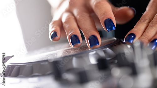 female DeeJay hands on a DJ modern console photo