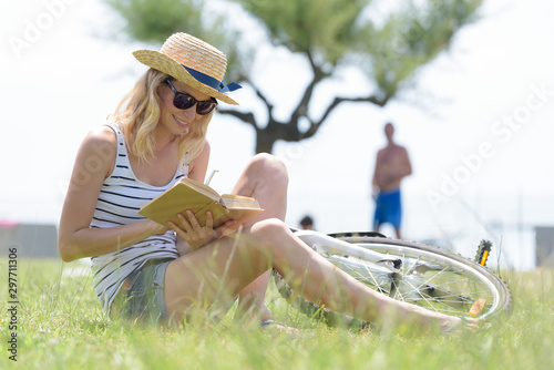 woman sitting on the grass reading © auremar