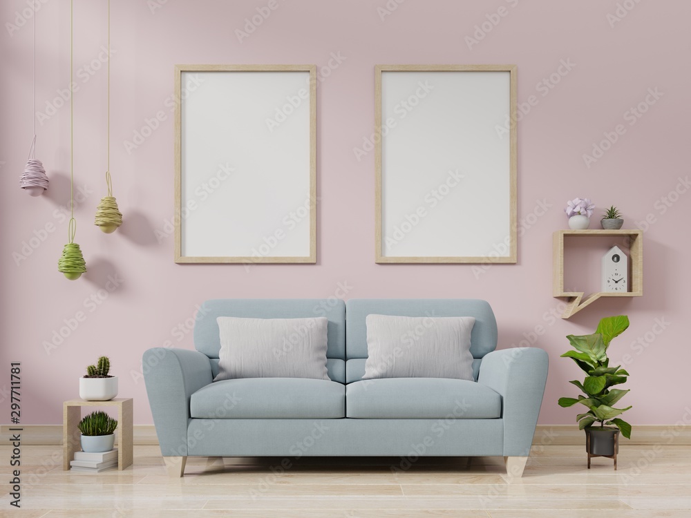Interior poster mockup with vertical empty wooden frame standing on wooden floor with sofa on pink background.