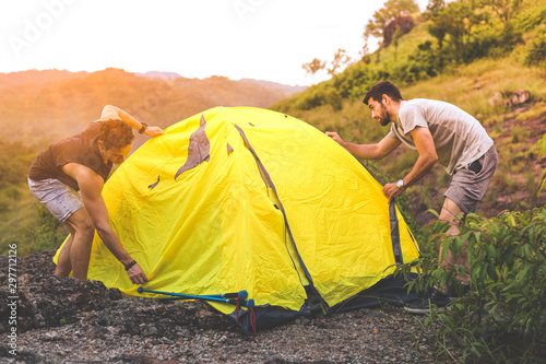 People pitching a tent on the ground near the mountain. Relaxing holiday travel long holiday concept.