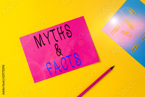 Writing note showing Myths And Facts. Business concept for usually traditional story of ostensibly historical events Blank paper sheets message pencil clips binder plain colored background