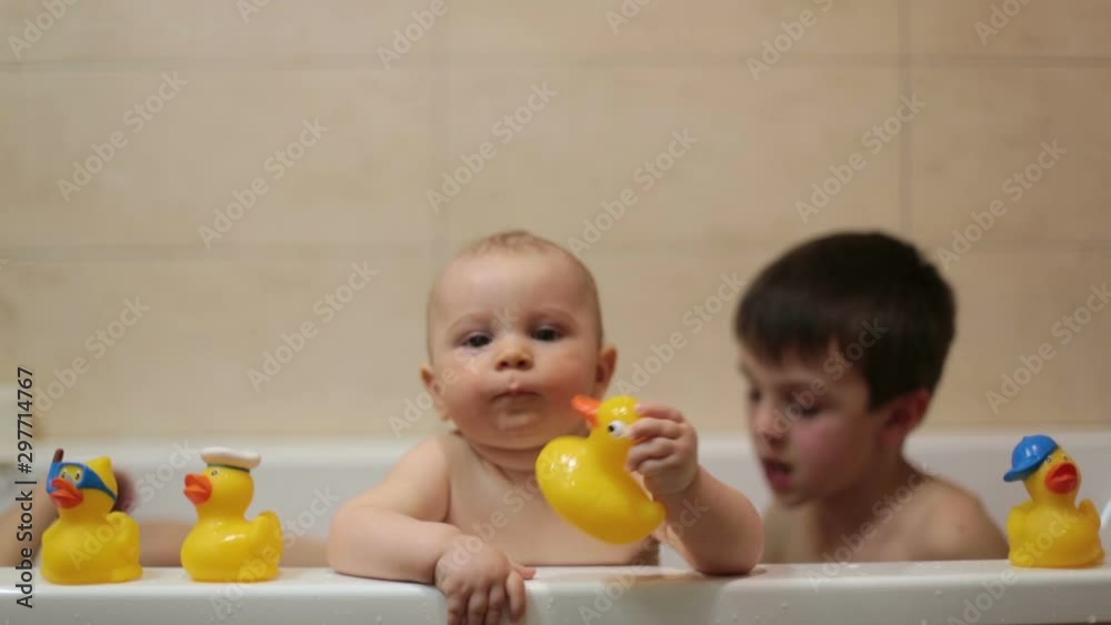 Little baby boy, playing with rubber ducks in bathtube with his siblings Little baby boy, playing with rubber ducks in bathtube with his siblings