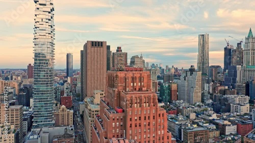 Drone footage with slow rotation in front of New York City Lower Manhattan skyscrapers on a sunny afternoon before sunset