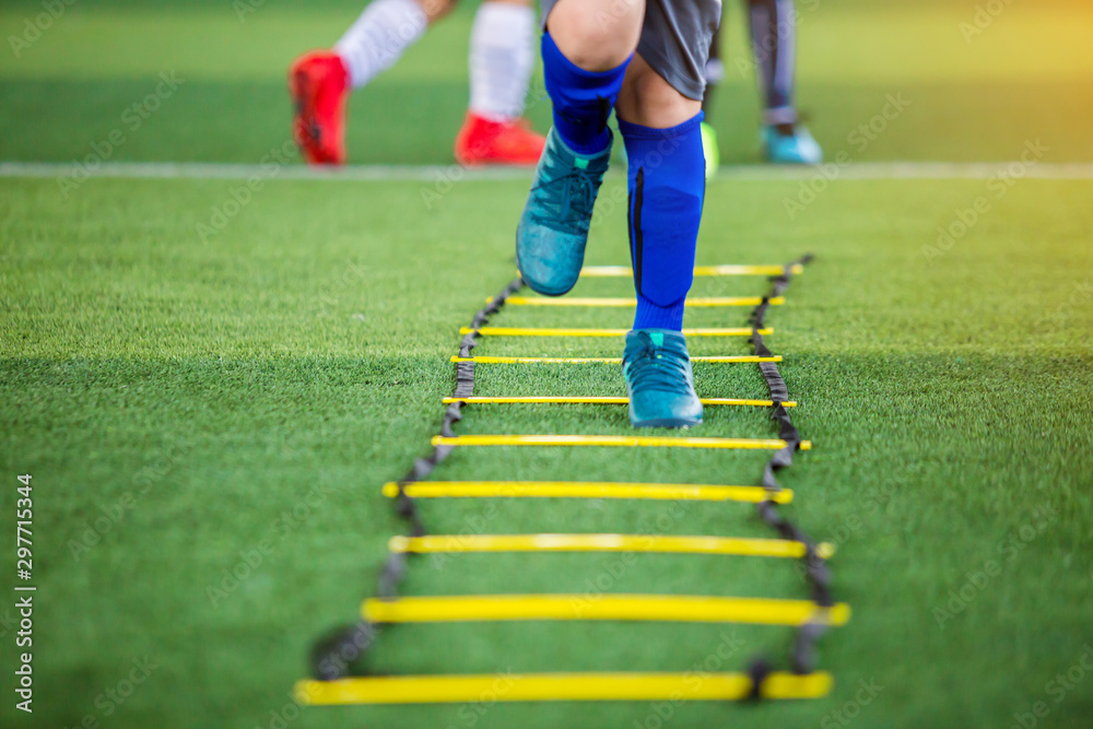 Kid soccer player Jogging and jump between marker for football training