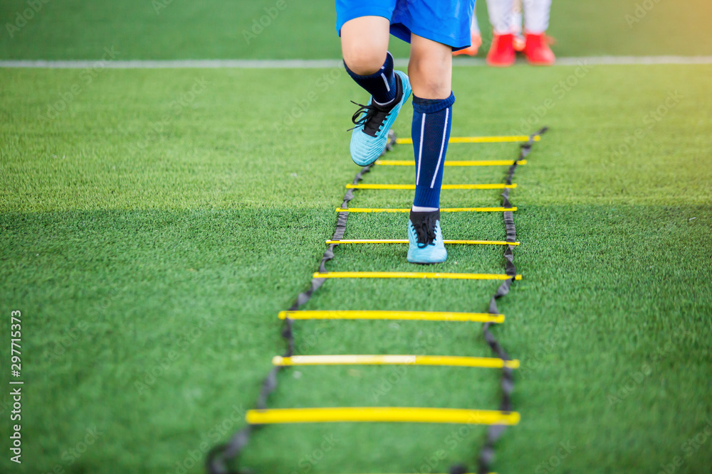 Kid soccer player Jogging and jump between marker for football training