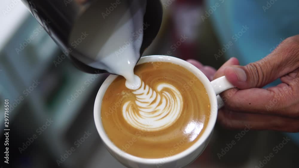 barista pouring milk to make coffee latte art. b-roll footage video 4k. cafe business shop.