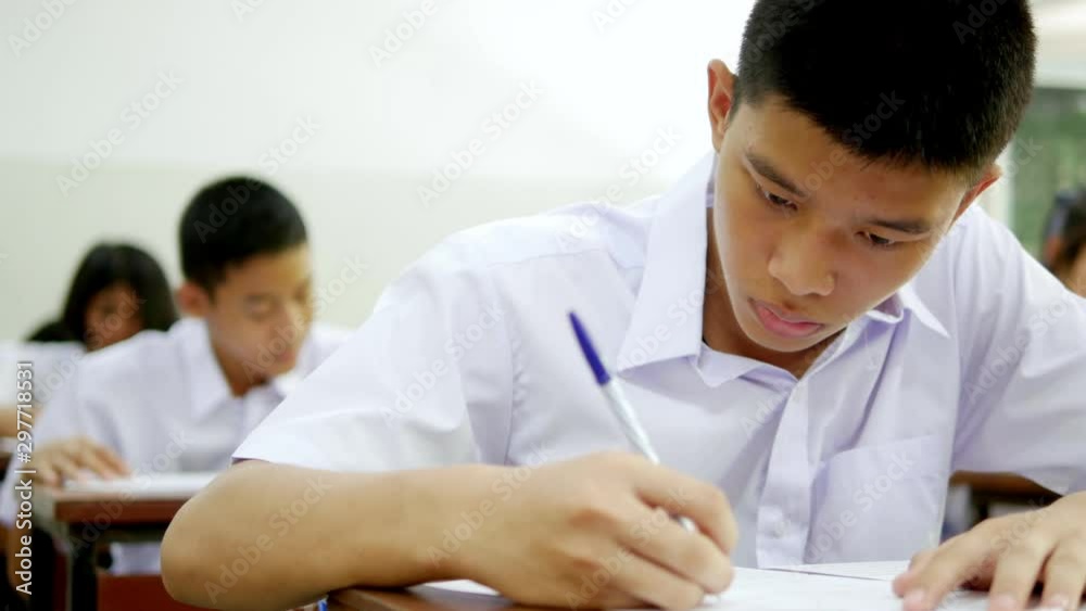 Asian high school students in white uniform are doing examinations. Asian high school students in white uniform are doing examinations.