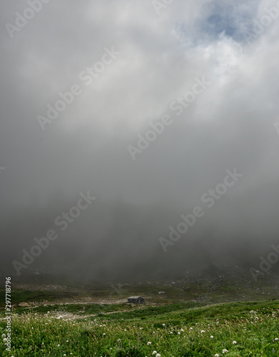 Thick Fog Over Alpine Field and Historic Building