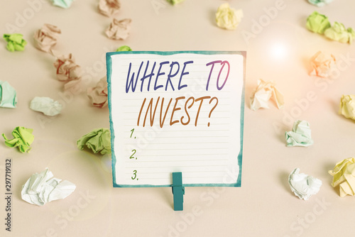 Handwriting text Where To Invest Question. Conceptual photo asking about where put money into financial schemes or shares Colored crumpled papers empty reminder pink floor background clothespin © Artur