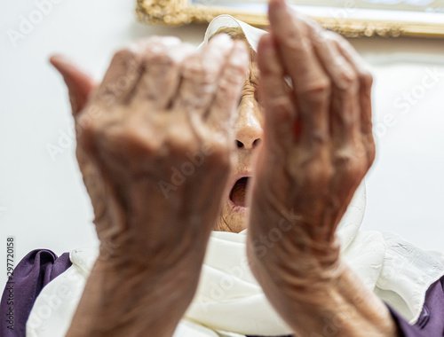 Old muslim woman praying for god to bless her and give her strength