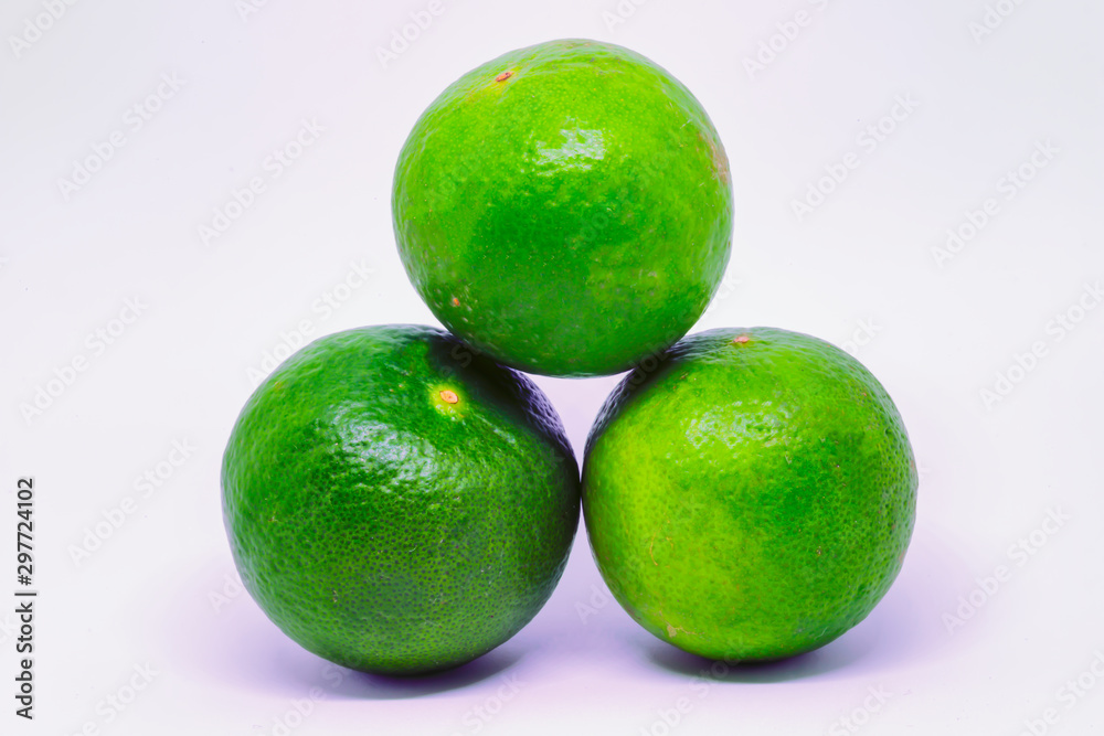3 round kiefer / key limes stacked in a pyramid isolated on a white background.