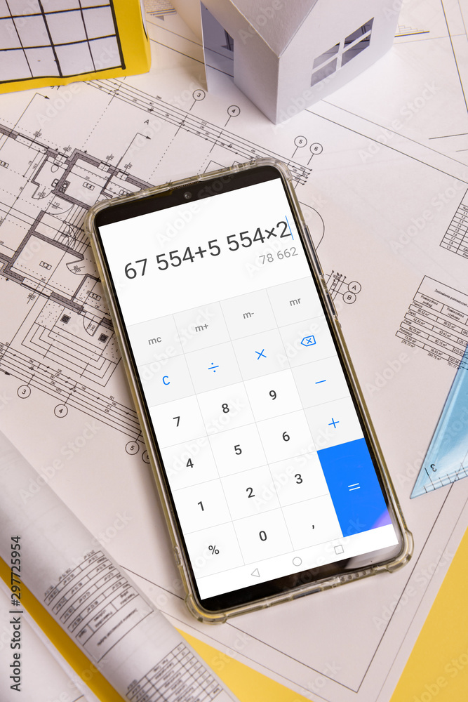 Counting the cost of building a house on a calculator .White family paper  house, block of flats. Minimalistic and simple concept, style. Copy space.  Vertical orientation. foto de Stock | Adobe Stock
