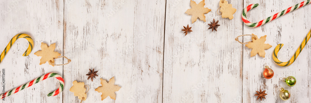 Christmas caramel canes and cookies on an aged white wooden background. Happy new year background, composition of christmas decorations. Holiday concept. Banner. Christmas caramel canes and cookies on an aged white wooden background. Happy new year background, composition of christmas decorations. Holiday concept. Banner.