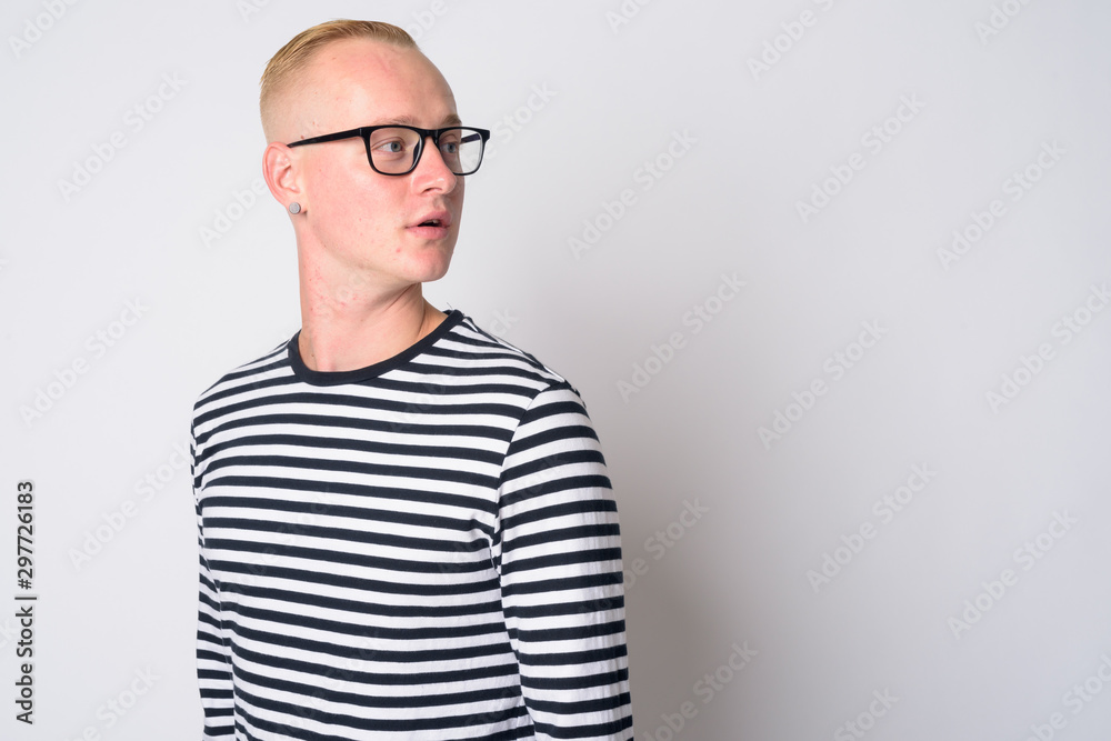 Face of young handsome blonde man thinking and looking back Face of young handsome blonde man thinking and looking back