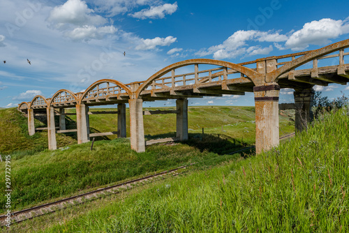 The old concrete bridge in Scotsguard, SK with railway tracks underneath photo