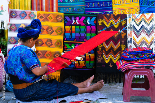 Mujer Maya está tejiendo con su telar de cintura en una calle de San Antonio Palopó Guatemala. photo