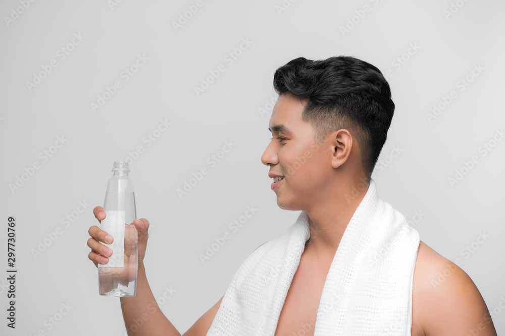 image of handsome smiling man with white towel on his shoulders holding bottle of water after workout white background image of handsome smiling man with white towel on his shoulders holding bottle of water after workout white background