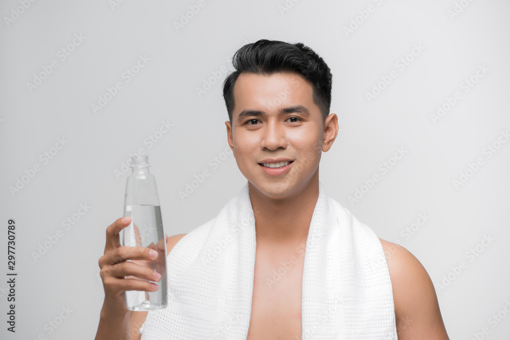 image of handsome smiling man with white towel on his shoulders holding bottle of water after workout white background image of handsome smiling man with white towel on his shoulders holding bottle of water after workout white background