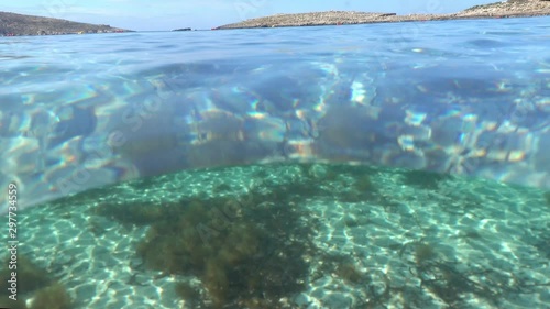 Under and Above Clear, Blue Water and stone Mountains on Malta. Dome Port underwater and sky photo