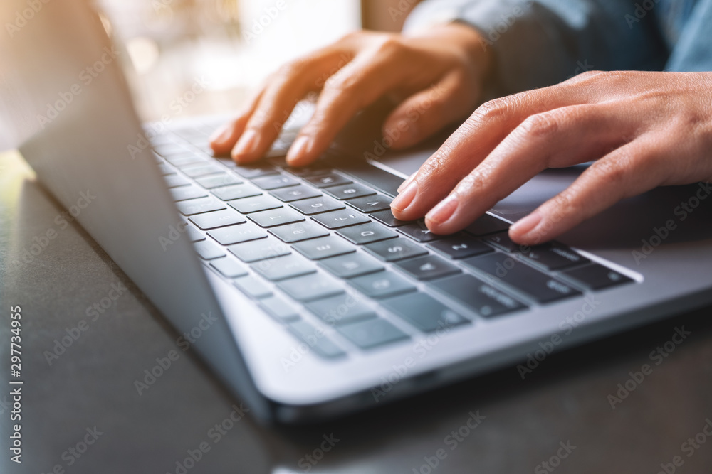 Closeup image of a woman working and typing on laptop computer on the table Closeup image of a woman working and typing on laptop computer on the table