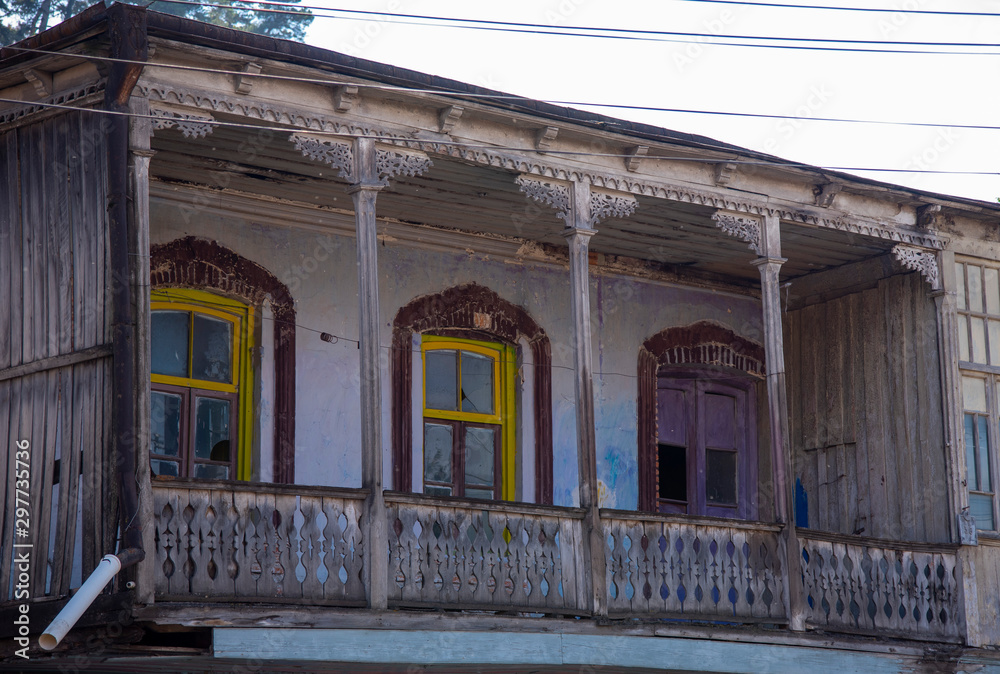 Wooden balcony with carved railings and casings on the Windows.