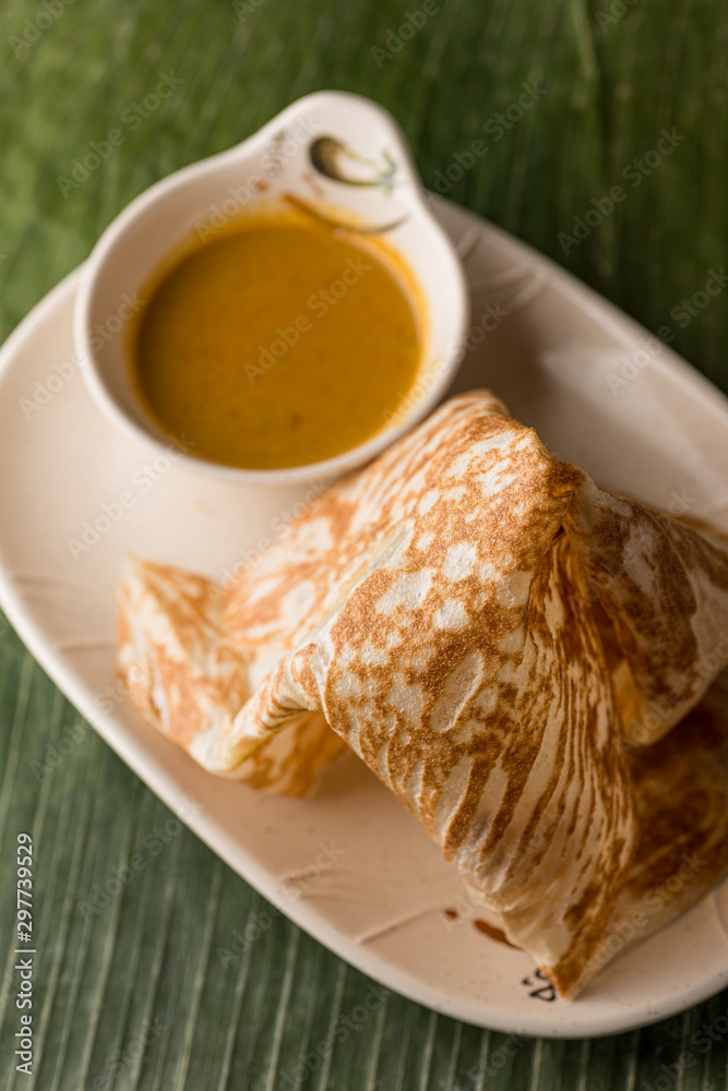 Malaysian Indian cuisine Roti Prata bread with curry dipping sauce