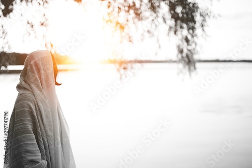 Person wearing a biblical robe looking in the distance shot from behind photo