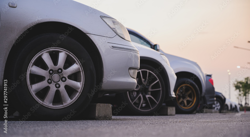 Many cars are parked in a large parking lot. Arranged in a long line Was the time when the sun was setting Many cars are parked in a large parking lot. Arranged in a long line Was the time when the sun was setting