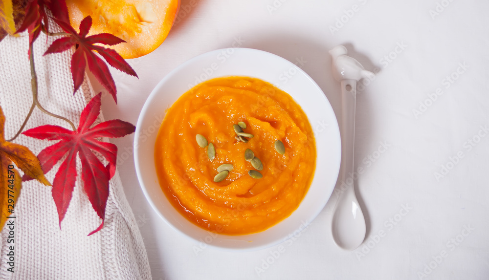 Pumpkin soup in a white bowl on thewhite table. Autumn concept. Harvest. Pumpkin soup in a white bowl on thewhite table. Autumn concept. Harvest.