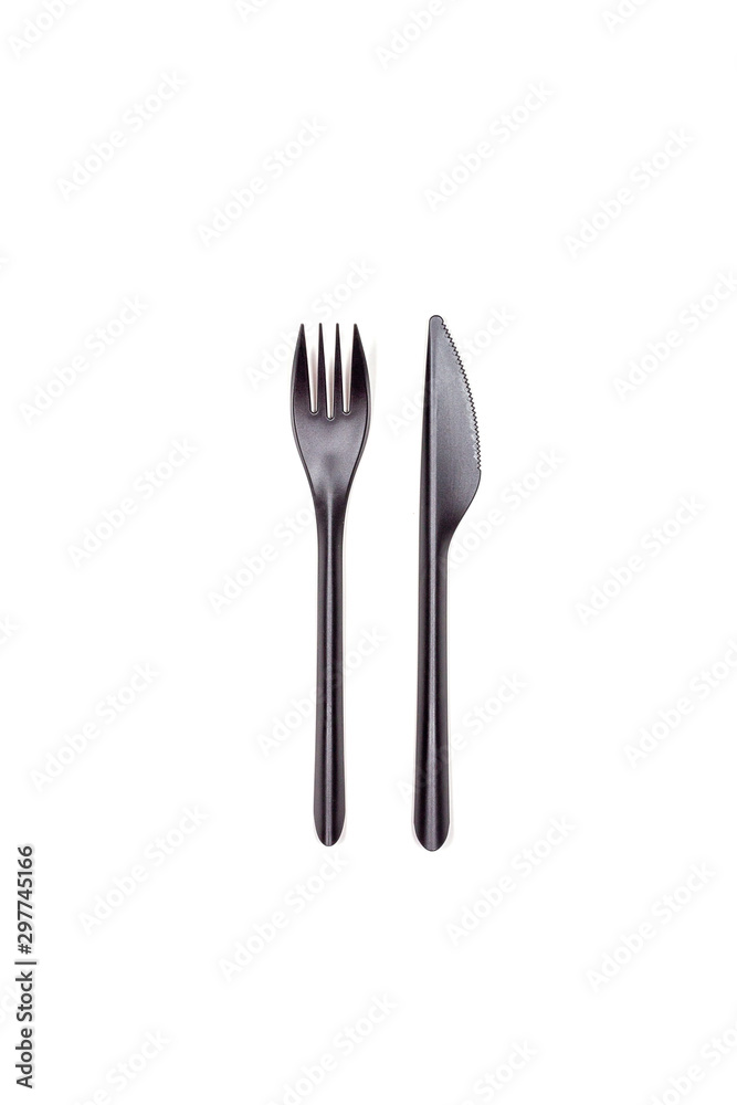 Black fork and knife isolated on white background. Disposable tableware. Flatlay. Fast food, eco and no plastic concept. Black fork and knife isolated on white background. Disposable tableware. Flatlay. Fast food, eco and no plastic concept.