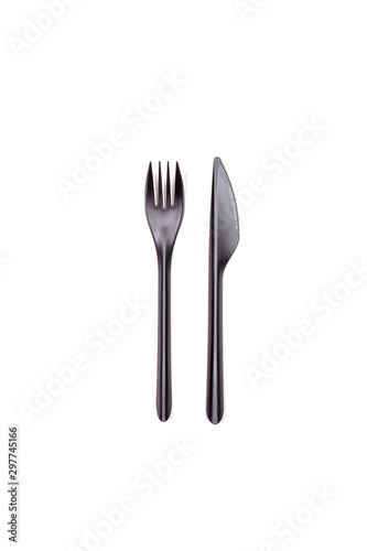 Black fork and knife isolated on white background. Disposable tableware. Flatlay. Fast food, eco and no plastic concept.