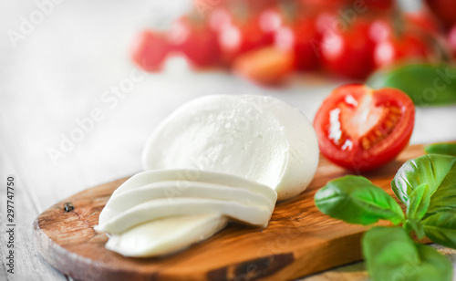 Εκτύπωση καμβά Fresh finest tomatoes on white rustic board with basil and mozzarella cheese close up or detail