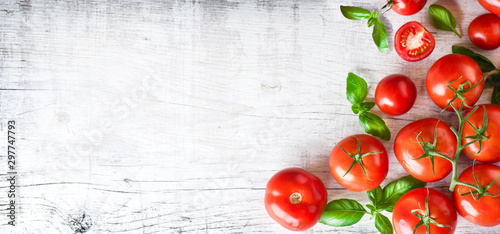 Fresh ripe tomatoes on white background top view. Tomato red vegetable concept, copy space for text with basil leaves. photo