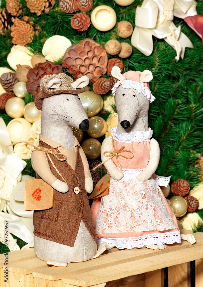 Pair of decorative toy mice festively dressed on the eve of the rat year on the background of the New Year tree. Pair of decorative toy mice festively dressed on the eve of the rat year on the background of the New Year tree.