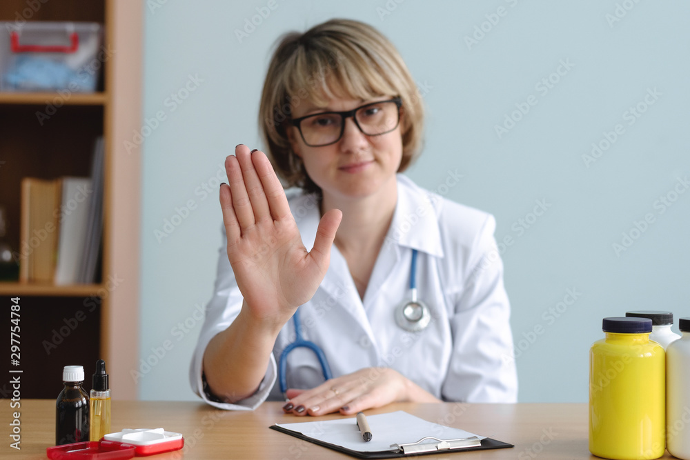 Woman a doctor is showing a stop gesture by her hand. No panic. Do not worry concept. Denial in medical examination. Woman a doctor is showing a stop gesture by her hand. No panic. Do not worry concept. Denial in medical examination.