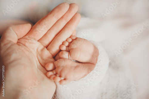 Newborn Baby's feet. Mother and father holding newborn baby legs,legs massage concept of childhood, health care, IVF, hygiene