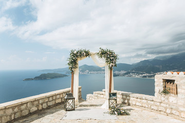 Beautiful wedding arch with flowers on the background of the sea in Montenegro. Preparation for a wedding event.