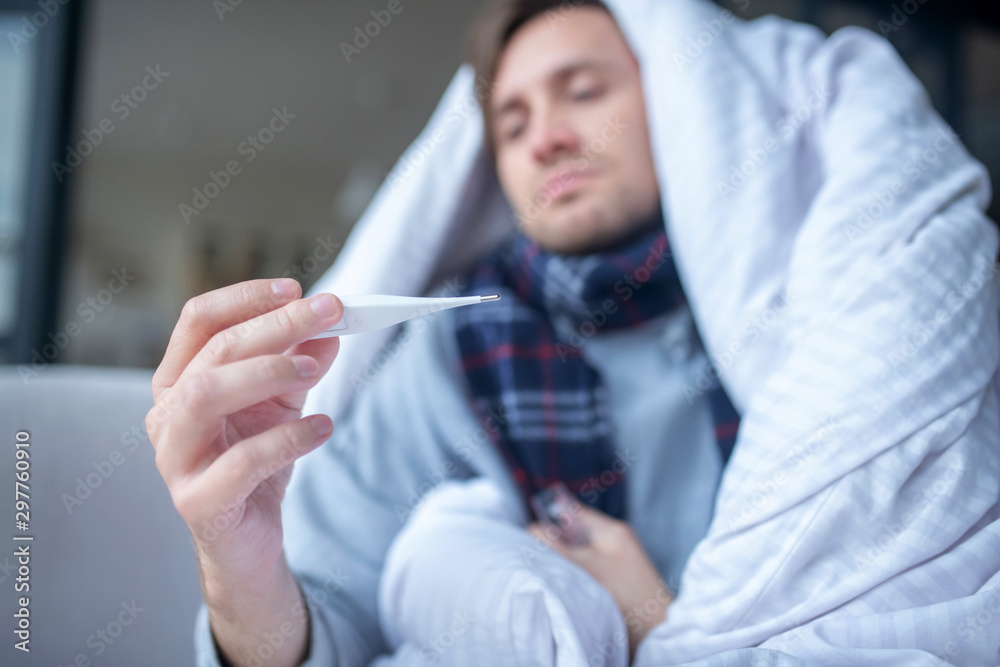 Close up of man feeling cold measuring body temperature