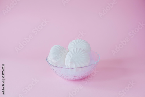Delicious sweet marshmallows and cute little toy on pastel pink background