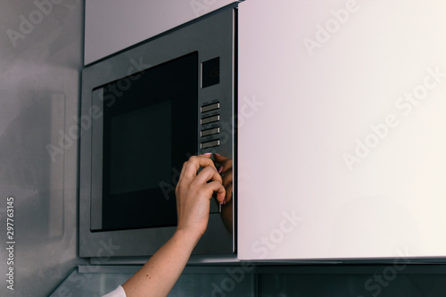 girl warms up food in the microwave