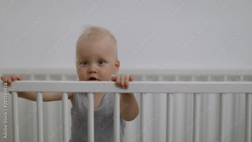 cute smiling baby boy playing in cot cute smiling baby boy playing in cot