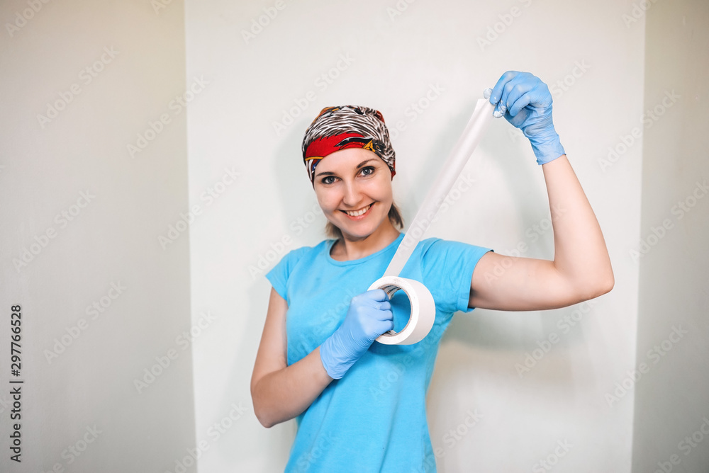 The girl is preparing to repair in the apartment, house or office. She with brush paints the wall. Advertising prospectus of building tools and materials. The moving and workers making repairs The girl is preparing to repair in the apartment, house or office. She with brush paints the wall. Advertising prospectus of building tools and materials. The moving and workers making repairs