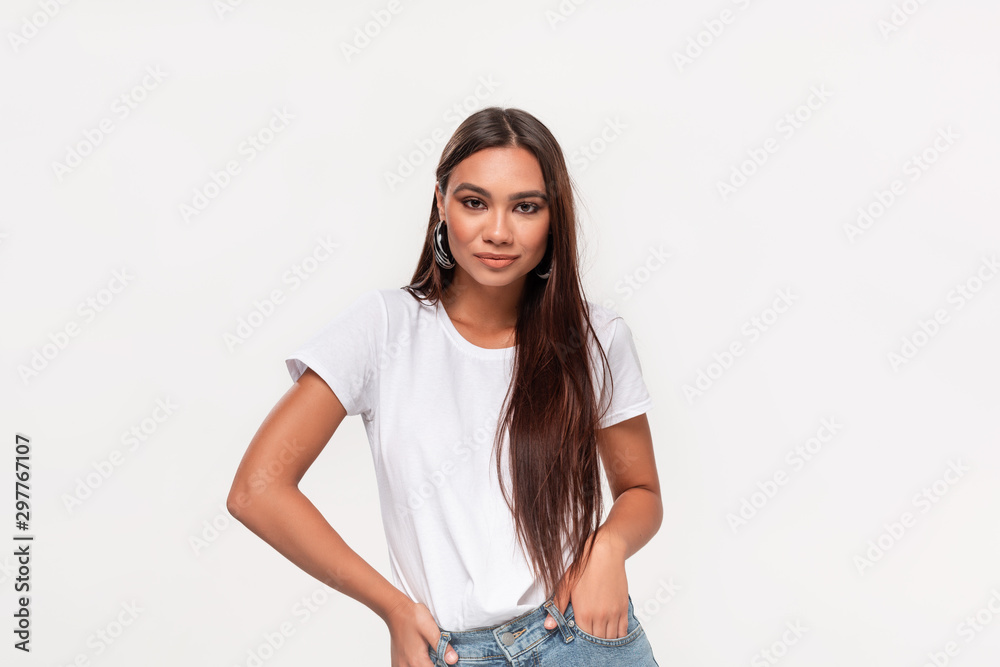Beautiful african-american teenager in a white t-shirt and blue jeans isolated over white background. Beautiful african-american teenager in a white t-shirt and blue jeans isolated over white background.